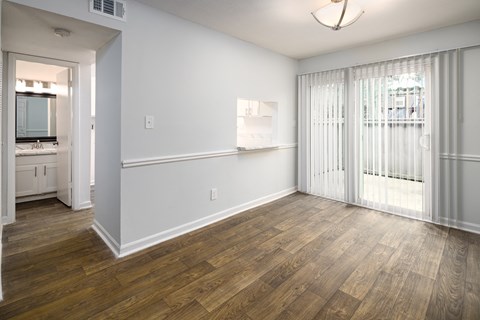 an empty living room with wood flooring and a sliding glass door