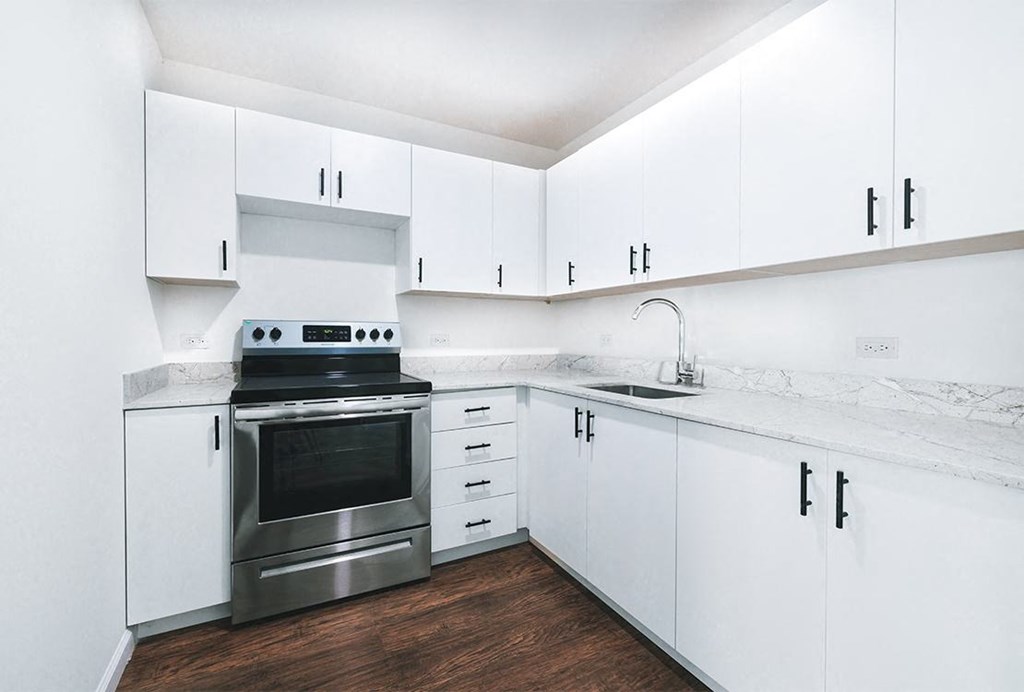 a white kitchen with stainless steel appliances and white cabinets