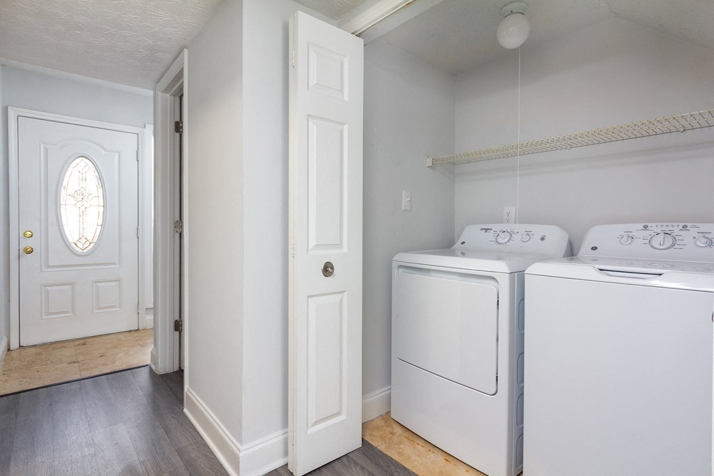 an empty laundry room with two washer and dryers