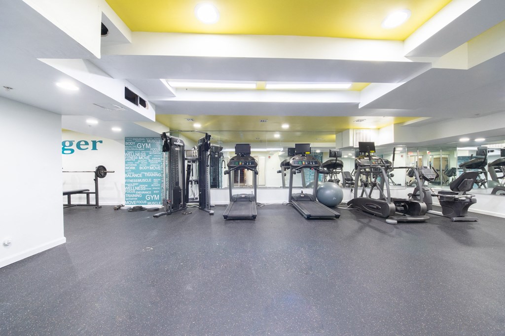 a gym with cardio machines and weights on the floor of a building