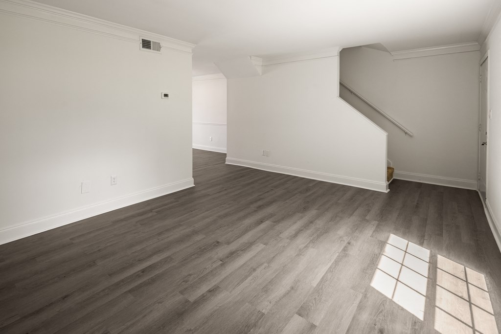 an empty living room with white walls and wood floors