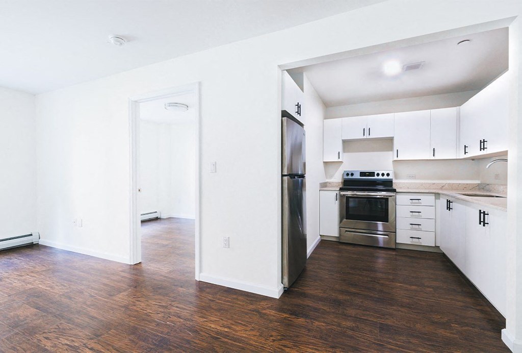 a renovated kitchen with white cabinets and stainless steel appliances