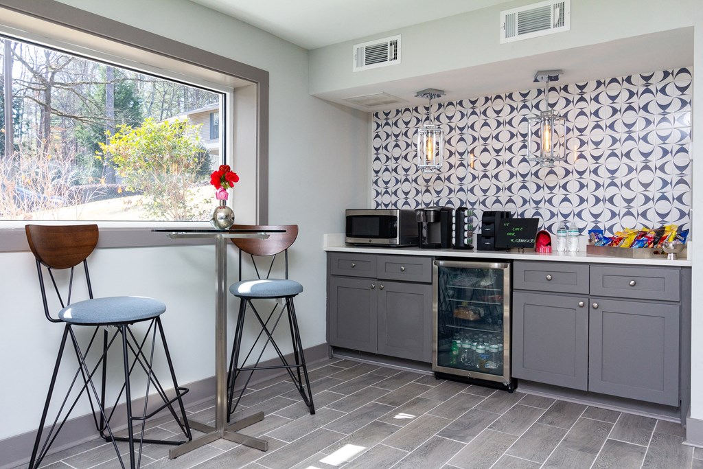 a kitchen with a bar and stools and a window