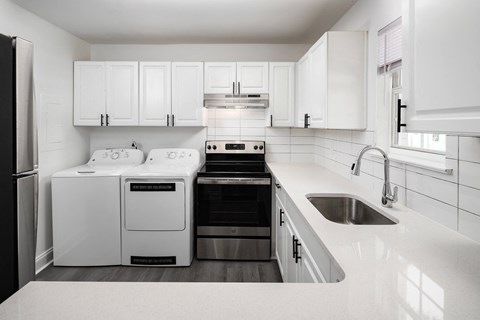 a white kitchen with white appliances and white cabinets
