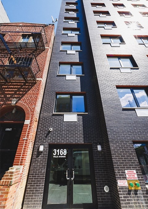 a tall brick building with a black door and windows