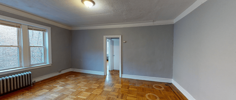the living room of an empty house with wood flooring and a door to a