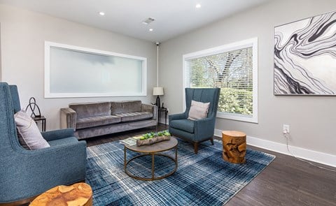 a living room with two blue chairs and a couch