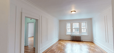 a living room with white walls and a window