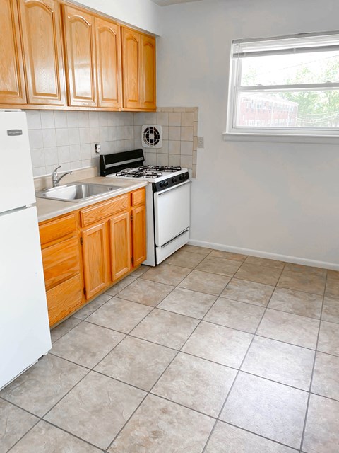 A kitchen with wooden cabinets and a white refrigerator.