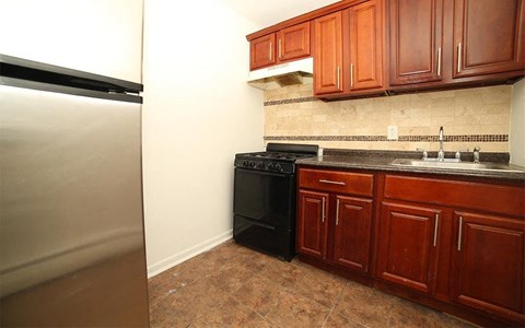 A kitchen with brown cabinets and a black stove.