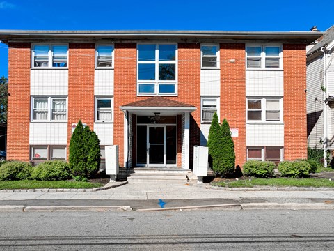 A red brick building with a white door and windows.