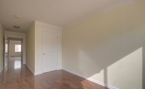 A long hallway with a white door at the end.