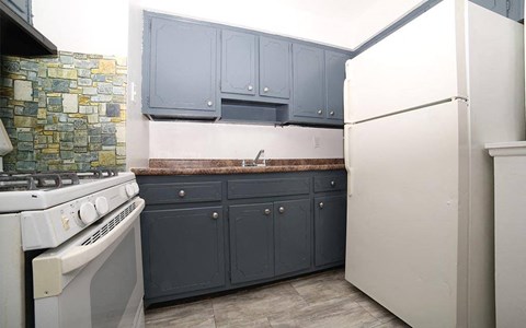 A kitchen with a white refrigerator and a stove with a white top.