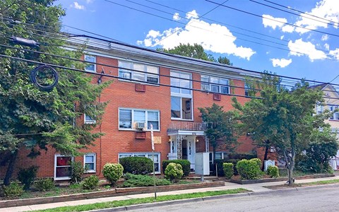A red brick building with a white door and windows.