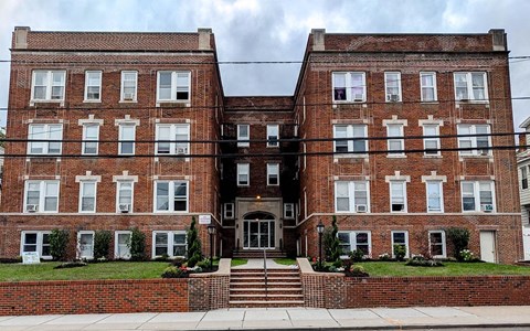 A red brick building with a white door and windows.