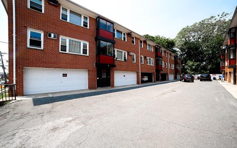 A parking lot in front of a red brick apartment building.