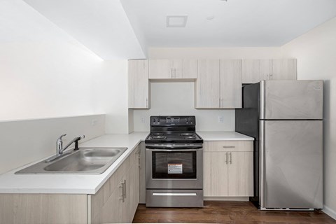 an empty kitchen with white cabinets and stainless steel appliances