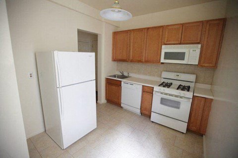a kitchen with white appliances and wooden cabinets