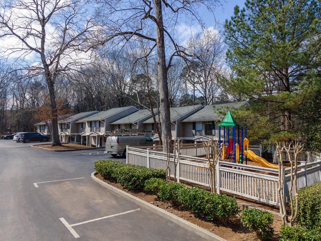 a parking lot filled with houses with playground equipment