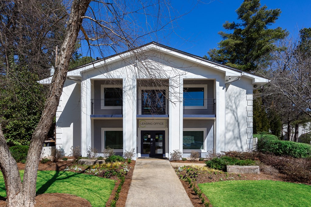 a white building with a sidewalk in front of it