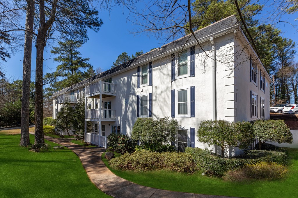 A white building with a green lawn in front.