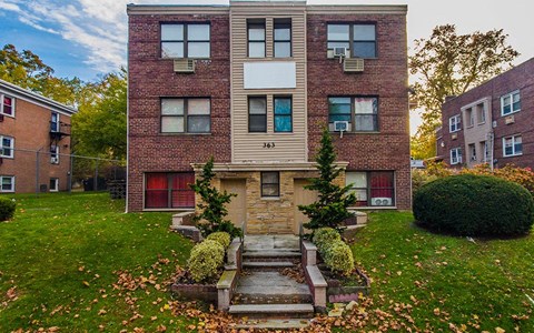 the front of a brick apartment building with steps in front of it