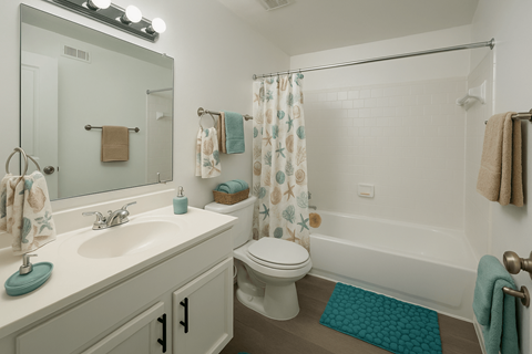A white bathroom with a toilet, sink, and shower.
