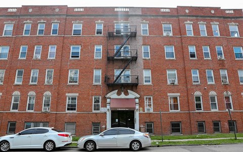 two cars parked in front of a brick building