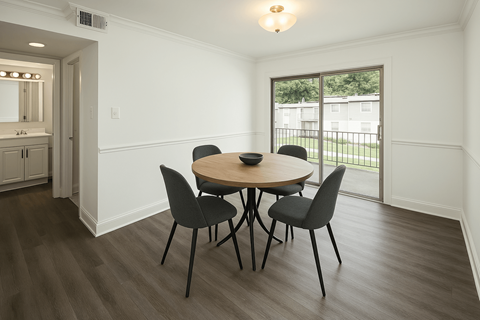 A dining room with a round table and four chairs.