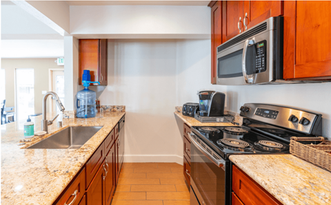 the kitchen has granite counter tops and stainless steel appliances