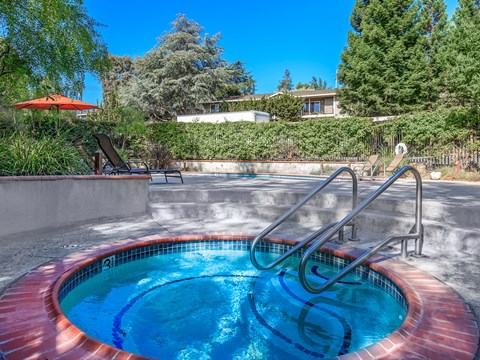 A small round pool with a red border and a metal ladder.