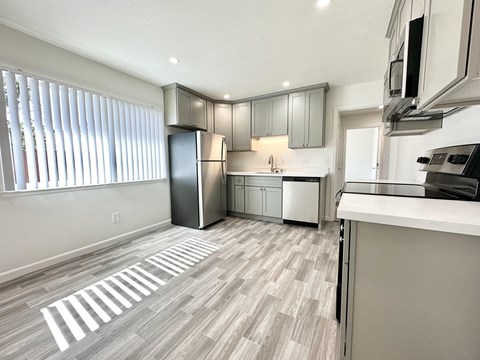 a kitchen with gray cabinets and a white counter top