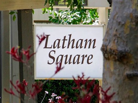 A sign that says Latham Square is mounted on a wall.