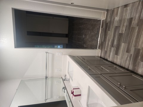 A modern kitchen with a white countertop and a microwave above it.