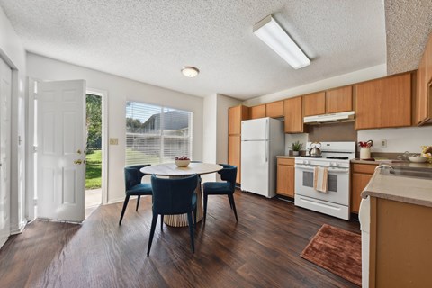 A kitchen with a table and chairs in the middle of the room.
