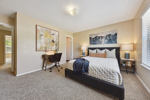 A bedroom with a large bed and a chair.
