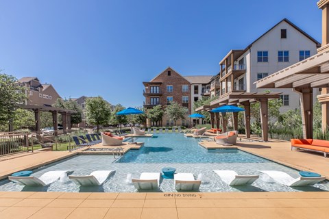 A large outdoor swimming pool with loungers and umbrellas.