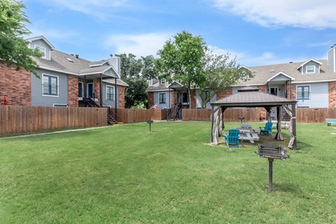 A backyard with a wooden fence and a gazebo.