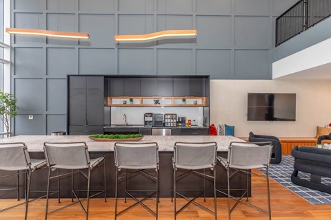 a kitchen with a large island with chairs in front of it