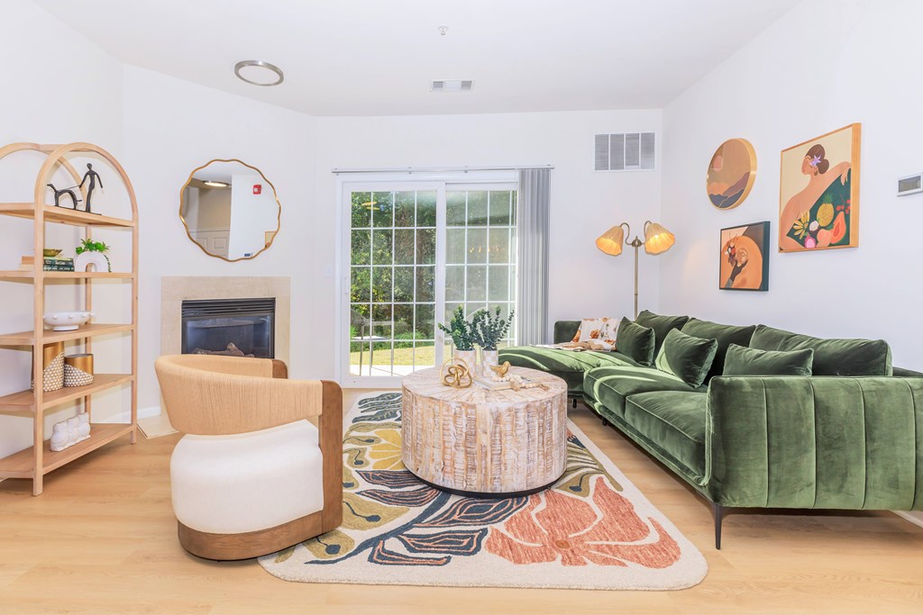 A living room with a green couch and a fireplace.