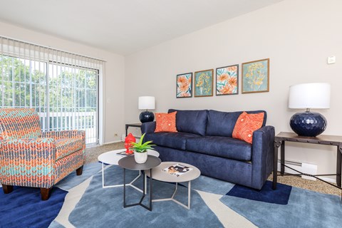 A living room with a blue couch and a white coffee table.