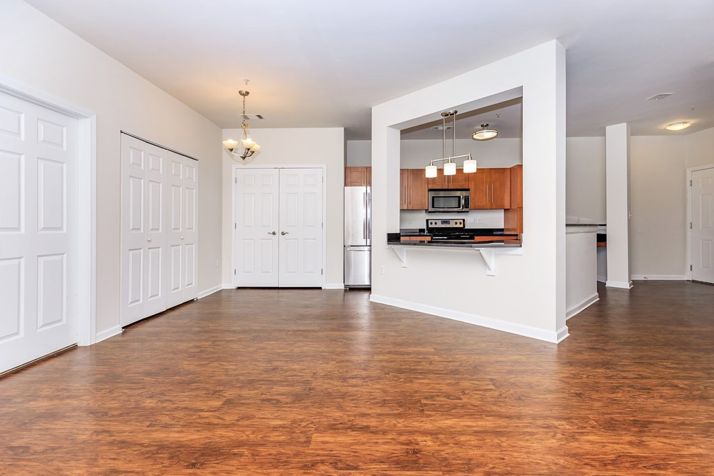 A kitchen with white cabinets and a wooden floor.