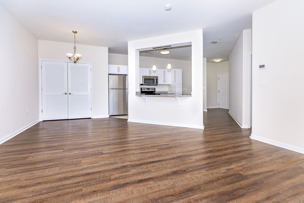 A spacious room with wooden floors and white walls.