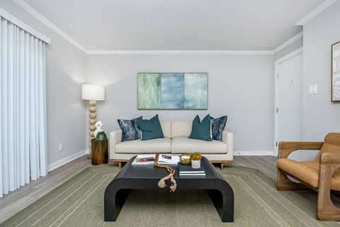 A living room with a white couch and a coffee table.