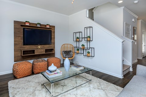 A living room with a glass coffee table and a wooden entertainment unit.