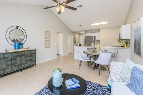 A living room with a white couch and a dining table.