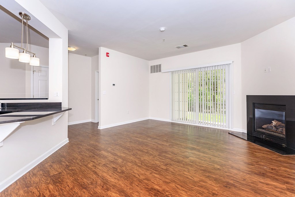 A living room with a fireplace and a window with blinds.