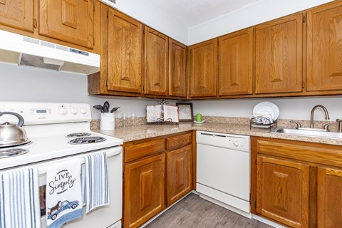 A kitchen with wooden cabinets and a white stove top.