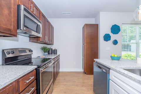 A kitchen with a white counter top and wooden cabinets.
