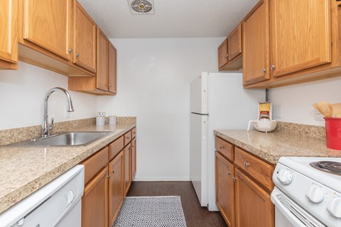 A kitchen with wooden cabinets and white appliances.